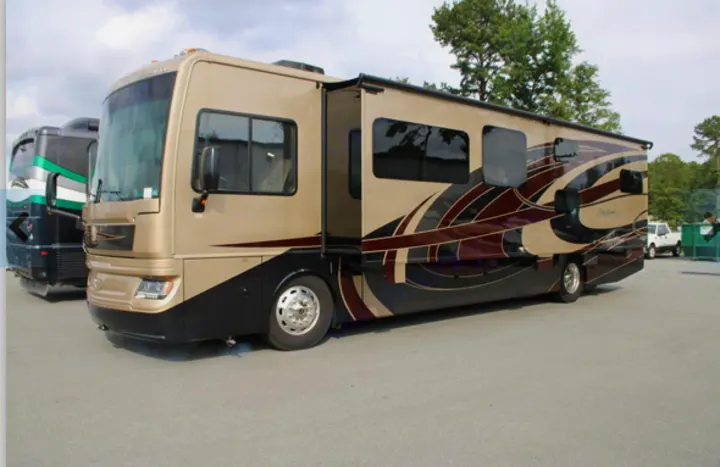 Spacious tan RV rental, a luxury motorhome with slide-out, parked on an outdoor lot.. Fleetwood Pace Arrow 2018