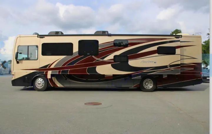Spacious beige and maroon motorhome, an ideal rv rental. Shows the recreational vehicle parked with slide-outs extended.. Fleetwood Pace Arrow 2018