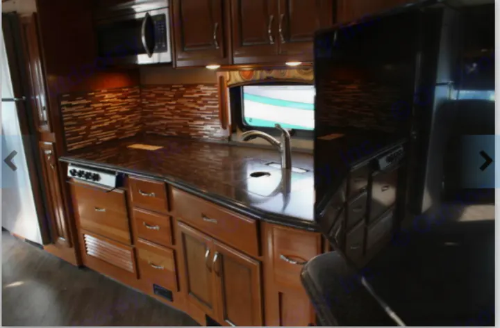 This RV rental offers a well-appointed kitchen with dark countertops, mosaic backsplash, and wood cabinetry.. Fleetwood Pace Arrow 2018