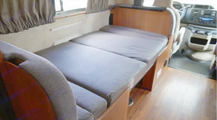 Cozy RV rental interior featuring a grey convertible bed.. Thor Motor Coach Four Winds Majestic 2013