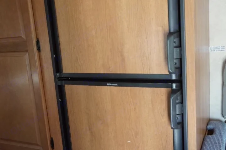 RV rental interior featuring a Dometic refrigerator with wood panel doors and secure travel latches.. Thor Motor Coach Four Winds Majestic 2013