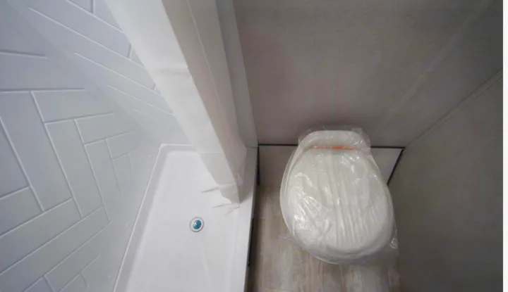 RV rental: Compact bathroom with white tiled shower and plastic-wrapped toilet. Essential amenities for your travels.. Prime Time Avenger 2021