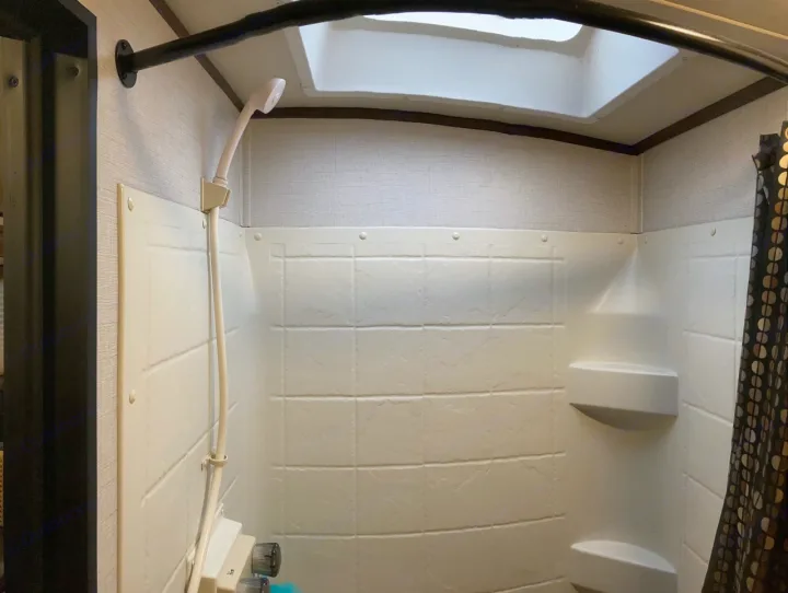Explore amenities in your RV rental, like this compact shower with handheld head, shelves, and skylight.. Palomino Solaire Ultra Lite 2017