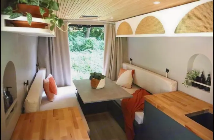 Cozy RV rental interior features a modern dining area, comfortable bench seating, and a compact kitchen counter.. Other Other 2015