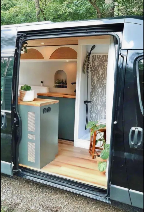 Stylish RV rental van conversion: a modern kitchen with green cabinets & a sleek shower with geometric walls.. Other Other 2015