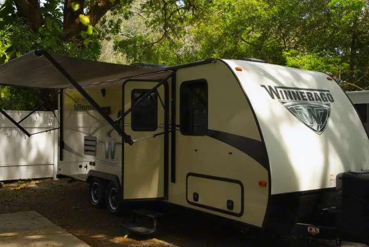 Discover a Winnebago Micro Minnie travel trailer RV rental at a serene campsite with its awning extended.. Other Other 2019