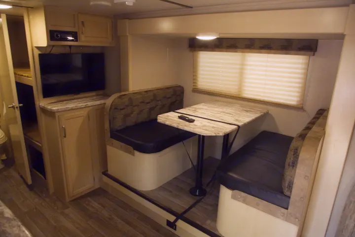 Explore this RV rental's inviting interior: functional dinette, comfy bunk beds, and a built-in entertainment system.. Other Other 2019
