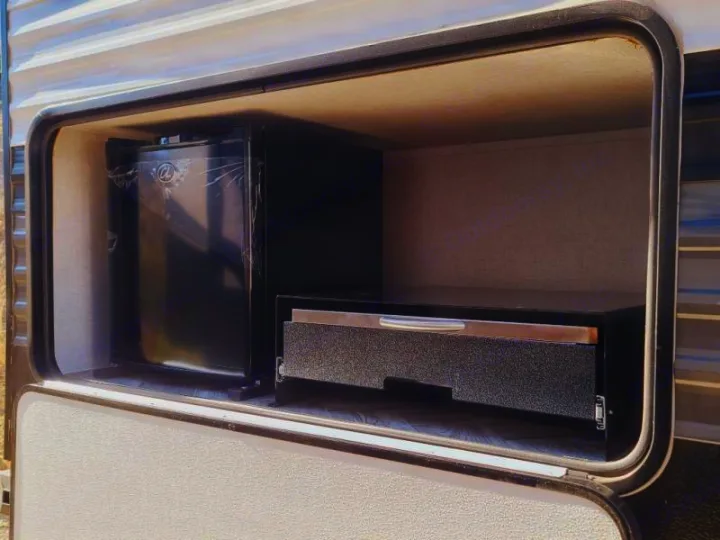 RV rental outdoor kitchen featuring a compact fridge & pull-out cooking station. Ideal for alfresco dining.. Forest River Wildwood 2021