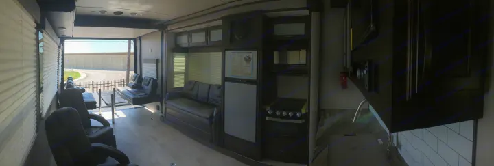 Spacious RV rental interior with open ramp, featuring comfortable seating and a modern kitchen.. Grand Design Momentum 2020