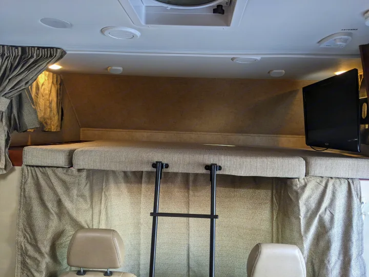 Discover the comfortable cab-over sleeping space in an RV rental, complete with an access ladder and entertainment TV.. Forest River Sunseeker 2016