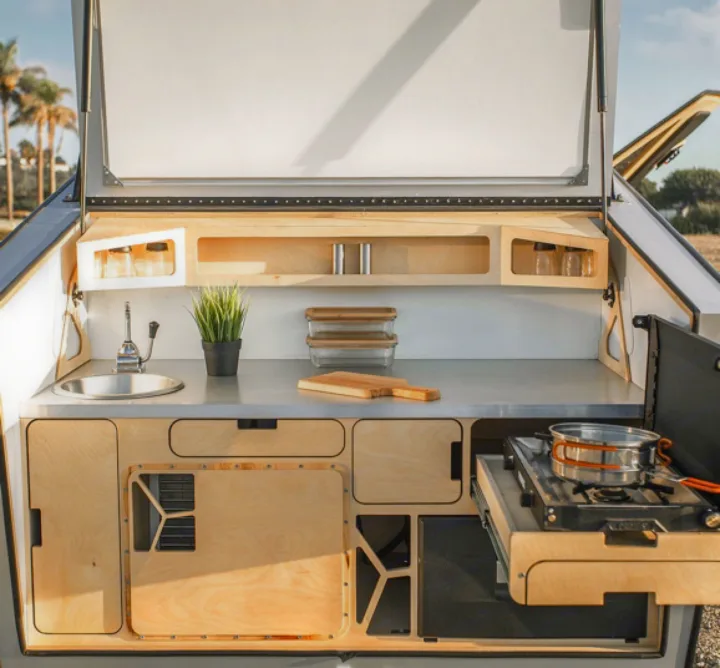 Stylish and functional outdoor kitchen in an rv rental, featuring a sink, pull-out stove, and smart storage.. Polydrop K-20 2020