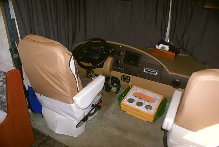 RV rental interior: driver's station with steering wheel, dashboard, infotainment, controls, and two front seats.. Winnebago Vista 2013