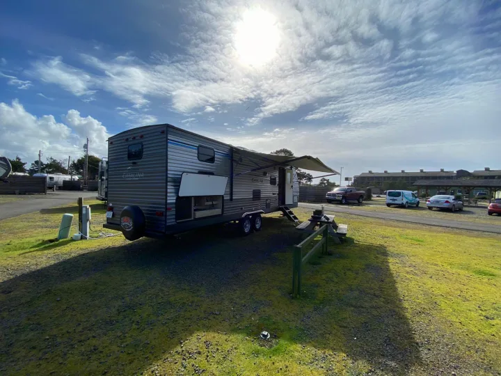 Enjoy your RV rental! This travel trailer is set up at a sunny campsite, ready for your next outdoor adventure.. Coachmen Catalina 2019