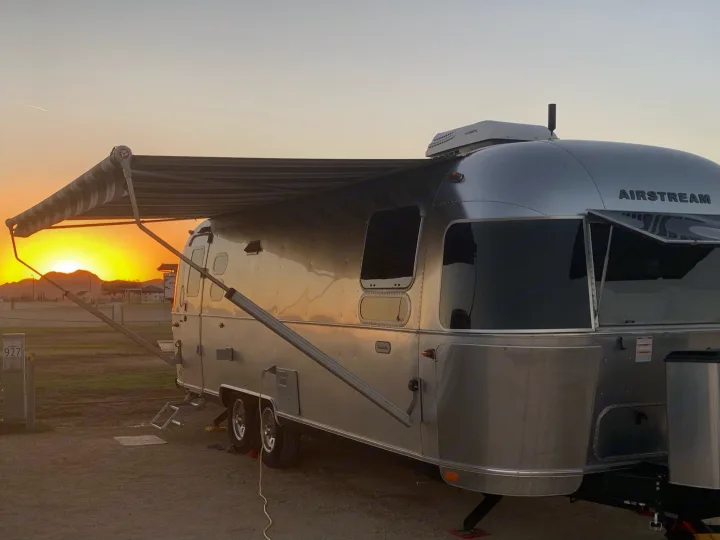 Sun setting over the lake behind our rig. The awning is out and we enjoyed drinks in the shade.. Airstream Globetrotter 2019