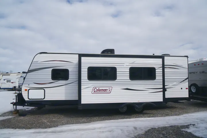 White Coleman travel trailer, great for rv rental, parked on a snowy gravel lot.. Coleman Lantern Edition 262 BH 2017