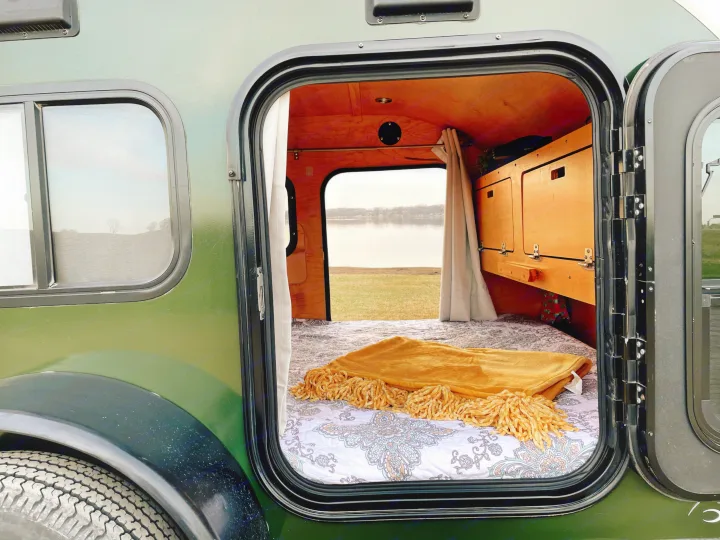 Step into this cozy RV rental camper with a comfortable bed and stunning lakeside view, perfect for a nature escape.. American Teardrop Travel Trailer 2016