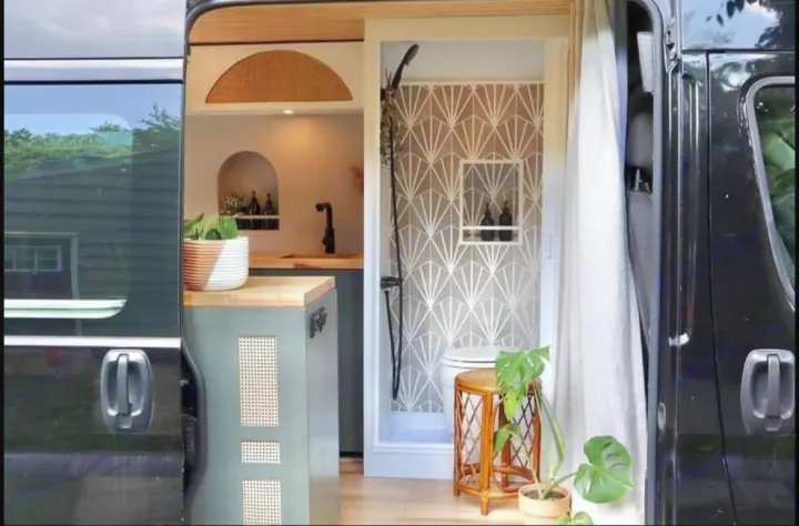 This RV rental showcases a chic camper van interior: compact kitchen, modern shower with patterned tiles, & lush plants.. Other Other 2015