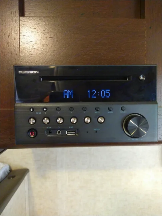 Furrion stereo system in an rv rental, with display showing time AM 12:05 & AUX input. Essential travel audio.. Forest River Cherokee Wolf Pup 2017