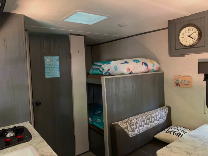 Cozy RV rental interior with bunk beds, dinette, and kitchen area, perfect for family adventures.. Aspen Other 2021