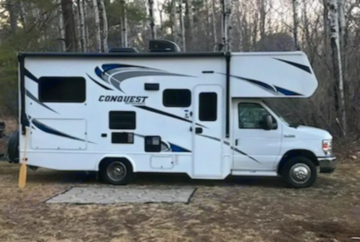 White Class C RV rental (Conquest model) parked at a rustic campsite, ready for your next outdoor adventure.. Gulf Stream Conquest 2018
