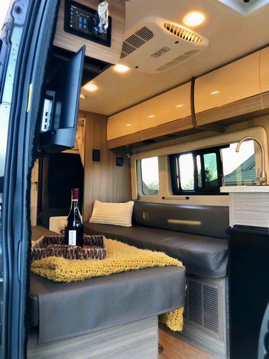Step inside this cozy RV rental's inviting living space, featuring a dining area, kitchen, and comfortable seating.. Jayco Swift 2021