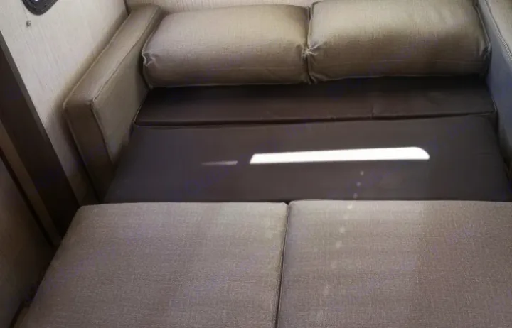 RV rental: Grey fabric sofa converts to a bed with dark base cushions, illuminated by a streak of sunlight inside.. Cruiser RV MPG Ultra Lite 2021