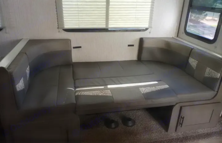 This RV rental's U-shaped dinette converts into a comfortable bed with gray and patterned cushions.. Cruiser RV MPG Ultra Lite 2021