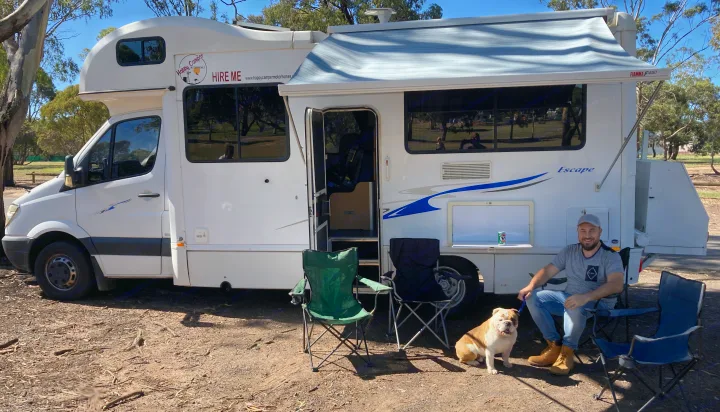 Happy Camper RV rental with a man and his bulldog enjoying a sunny outdoor day beside their motorhome.. Mercedes Dreamseeker River 6 2008