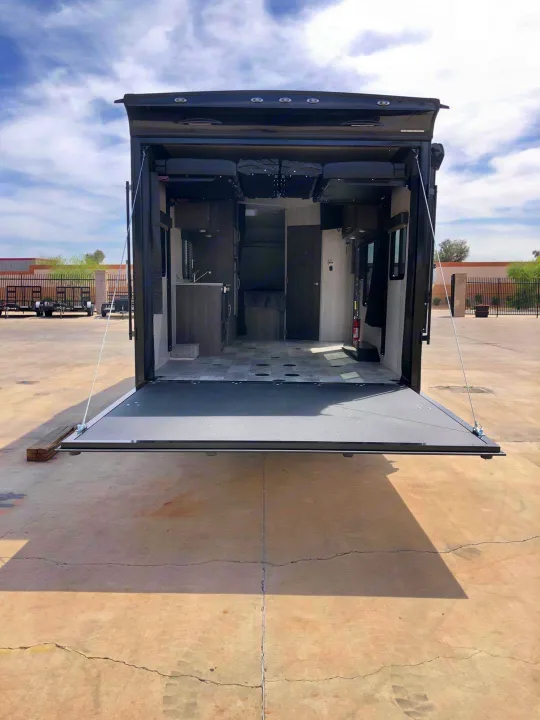 See inside this spacious RV rental toy hauler with its large rear ramp door lowered, showcasing the versatile interior garage space.. Genesis Supreme Rv Genesis Supreme 2021