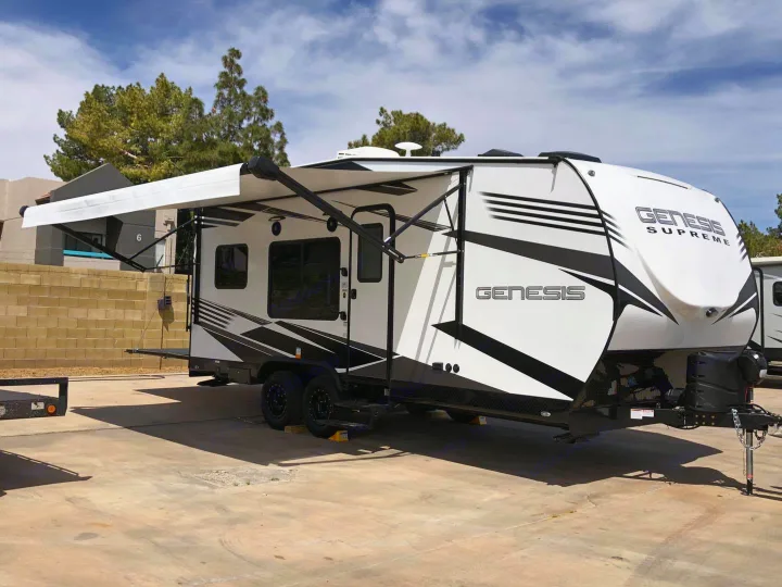White Genesis Supreme RV rental. Travel trailer with awning deployed, parked on concrete, ready for adventure.. Genesis Supreme Rv Genesis Supreme 2021
