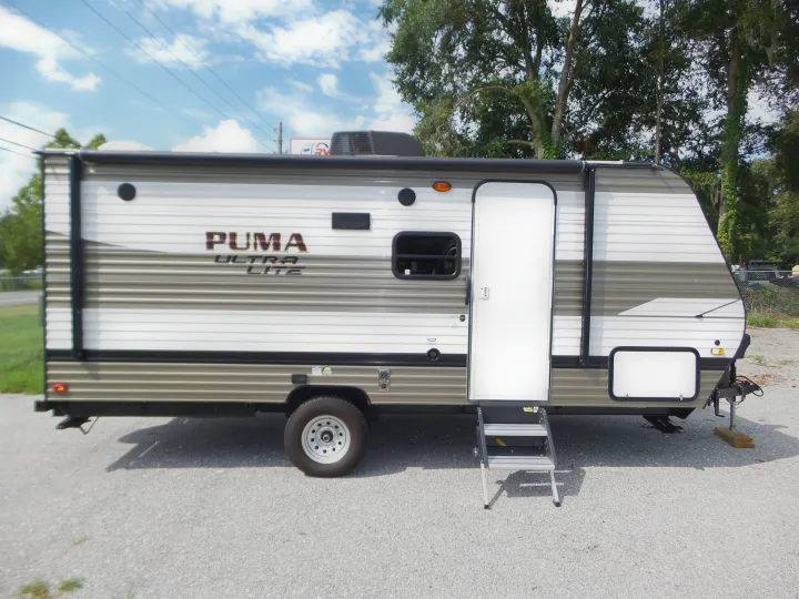 Side view of a white and grey Puma Ultra Lite travel trailer, perfect for your next RV rental trip.. Palomino 18SSX 2019