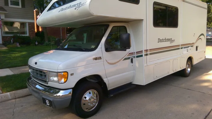 White Dutchmen Express RV rental (Ford E-450 Super Duty) parked on pavement, featuring its distinct Class C design.. Dutchmen Other 2001