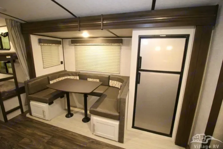 RV rental interior features a U-shaped dinette, modern refrigerator, and bunk beds for family adventures.. Other Bullet 2021