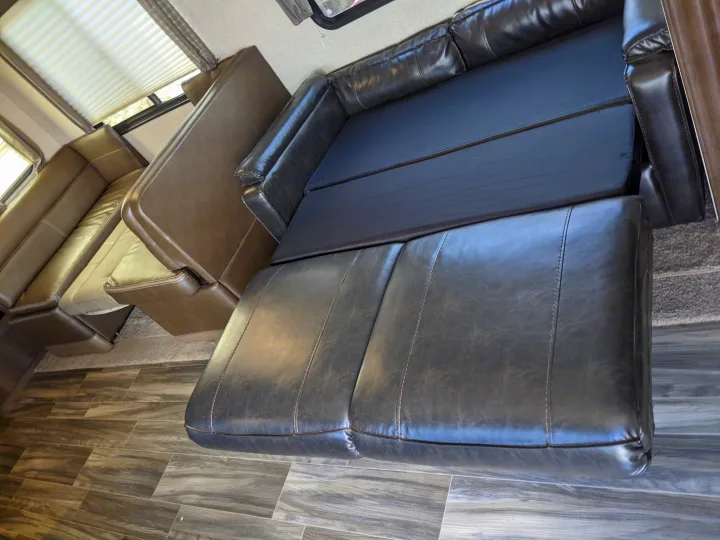 RV rental interior featuring a versatile convertible sofa bed and dinette, offering flexible seating and sleeping space.. Shasta Oasis 2019