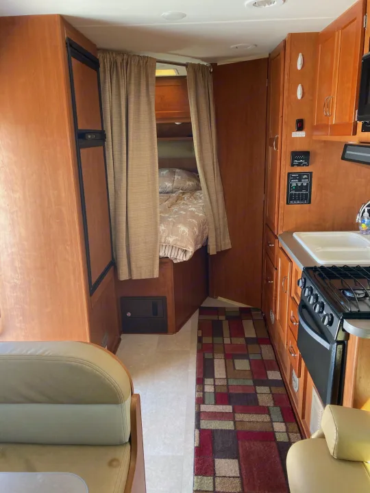 RV rental interior with kitchen, sleeping area, refrigerator, and ample storage. Compact and functional design.. Winnebago Minnie Winnie 2016