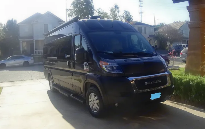 Dark RAM ProMaster RV rental van, perfect for adventures, parked on a residential driveway.. Thor Sequence 2021