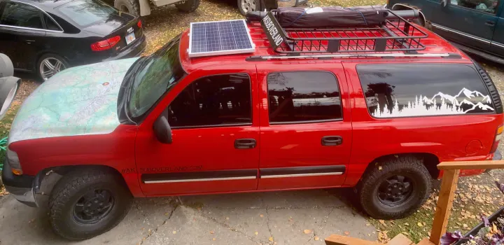 Custom red overlanding SUV with solar, map hood, and roof rack, perfect for an RV rental adventure.. Chevrolet Suburban Overland 2001