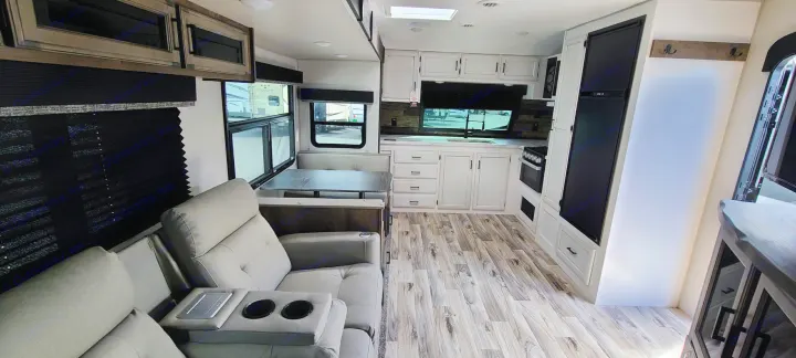 This inviting rv rental interior offers a comfy living area with recliners, a kitchen, and dinette seating.. Venture Rv Sporttrek 2021