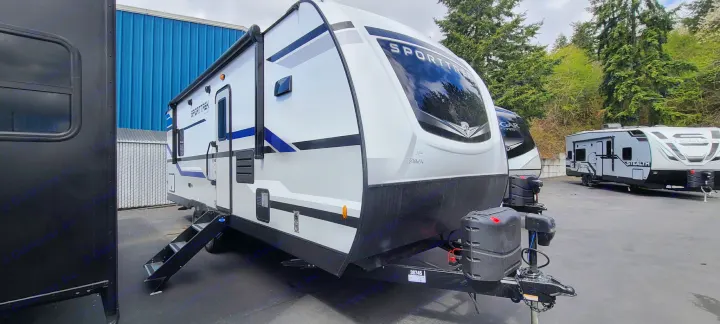 White Sporttrek travel trailer for rv rental, parked in a lot. Ideal for road trips and family adventures.. Venture Rv Sporttrek 2021