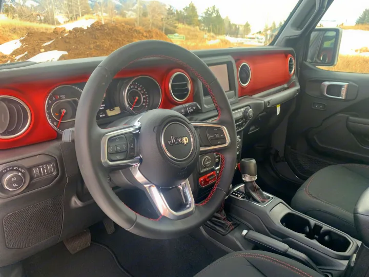 Jeep interior: red dash, steering wheel, controls. Ready for rugged use, complementing any rv rental adventure.. Jeep Gladiator Unlimited 2020