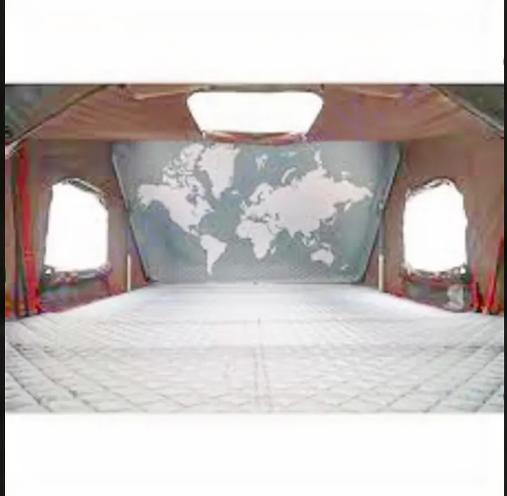 Experience the cozy interior of an RV rental: a spacious camper with a striking world map, comfy quilted bedding, and side windows, ready for your next travel adventure.. Jeep Gladiator Unlimited 2020