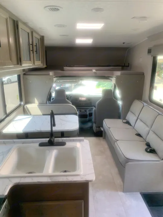 Spacious RV rental interior with kitchen, dinette, sofa, and overhead bunk for comfortable travel.. Coachmen Freelander 2022