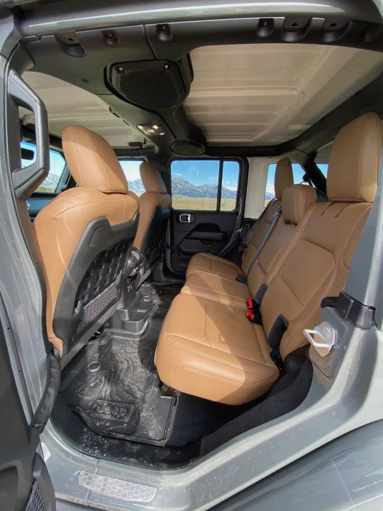 Spacious tan interior of a Jeep, with rubber mats & mountain views, perfect for an RV rental adventure.. Jeep Wrangler Unlimited 2021