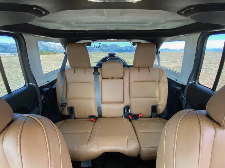 Tan interior of an off-road vehicle, looking out at mountains. Perfect for adventure trips or your next RV rental getaway.. Jeep Wrangler Unlimited 2021