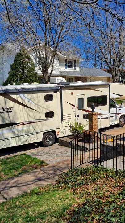Spacious RV rental parked in a sunny residential driveway, ready for adventure.. Coachmen Freelander 2015