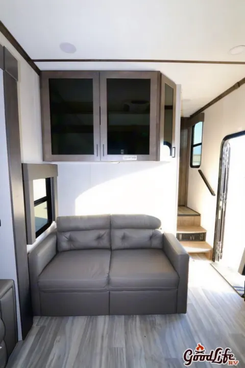 RV rental: Spacious interior featuring a comfortable gray sofa, sleek overhead cabinets, and steps leading to the upper level.. Alliance RV Valor 40V13 2021
