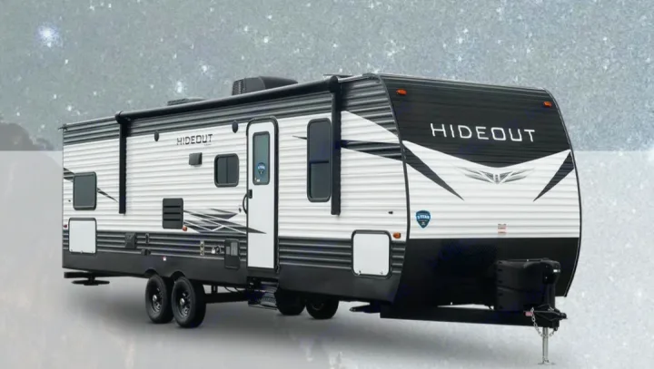 A spacious white and black 'Hideout' travel trailer, perfect for RV rental adventures and family camping trips.. Keystone RV Hideout 2021