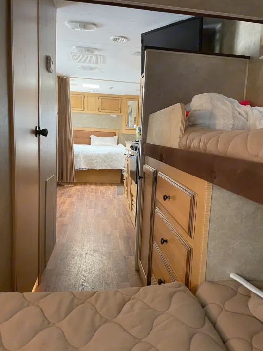 RV rental interior looking from bunk bed through kitchen to bedroom with wood floors.. K-Z Manufacturing Spree Ultra-Lite 2012