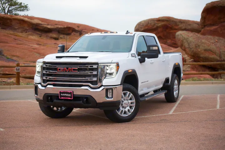 White GMC 2500 HD truck, parked by red rocks. Consider this powerful vehicle for your next adventure or rv rental journey.. GMC Sierra 2500HD 2021