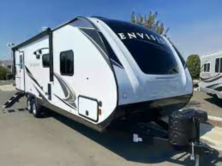 A modern white and black travel trailer with a large front window and black accents, branded "ENVISION." Great for RV rental.. Gulf Stream Envision 2021